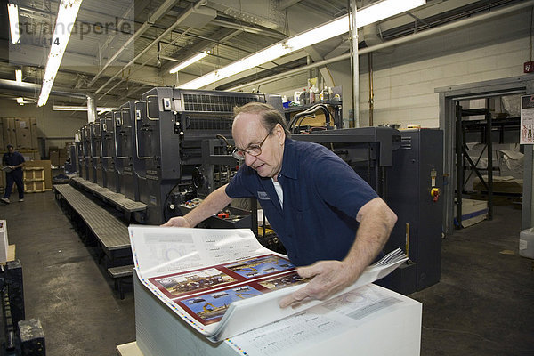 Ein Arbeiter lädt in der Goodwill Printing Druckerei Papier auf einer sechsfarbigen Heidelberg Speedmaster Offset-Druckmaschine ab  Ferndale  Michigan  USA
