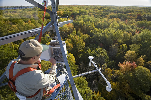 'Dr. Chris Vogel kontrolliert in einem 50 Meter hohen Turm über den Baumwipfeln in einer biologischen Station der Universität von Michigan Messinstrumente