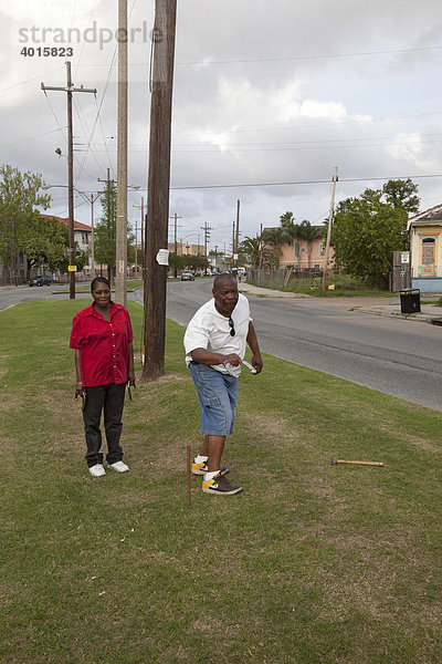 Ein Mann und eine Frau werfen beim Horseshoes-Spiel mit Hufeisen  Mittelstreifen der St. Claude Avenue  New Orleans  Louisiana  USA