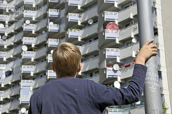 Ein Junge vor einem Wohnhochhaus mit Balkonen und Satellitenschüsseln  Trabantenstadt Chorweiler in Köln  Nordrhein-Westfalen  Deutschland  Europa