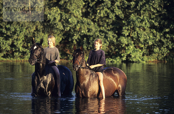 Mädchen und Pferde kühlen sich nach einem Ausritt im See ab  Metelen  Nordrhein-Westfalen  Deutschland