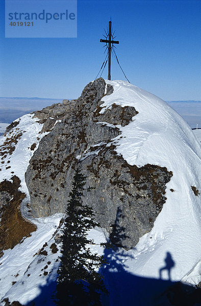 Schatten eines Mannes am Schnee unter dem Gipfelkreuz des Steinernen Jäger  Reichraming  Oberösterreich  Österreich  Europa