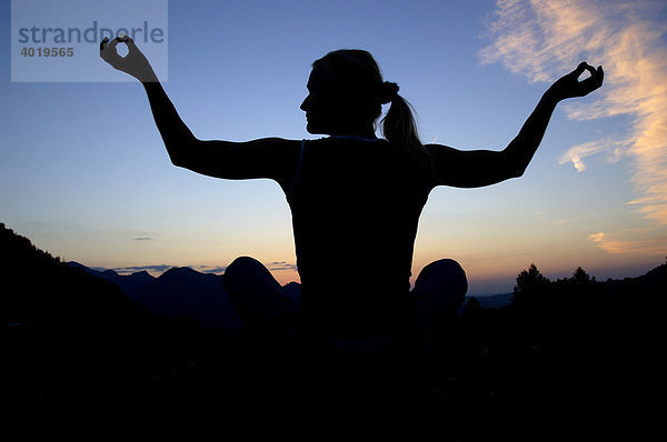 Frau betreibt Yoga am Abend  Silhouette