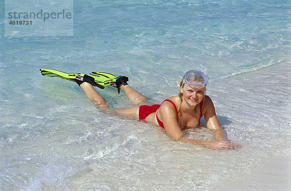 Blonde Frau  20 Jahre  mit Flossen und Taucherbrille liegt im flachen Wasser  Summer Island Village  Nord-Male-Atoll  Malediven  Indischer Ozean