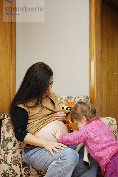 Eine schwangere Frau mit ihrer zwanzig Monate alten Tochter