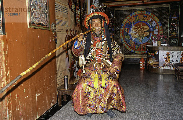 Naxi Dongba Schamane in traditioneller Kleidung  raucht Pfeife  Lijang  historische Hauptstadt des Naxi-Königreichs  UNESCO Weltkulturerbe 1997  Yunnan  China  Asien