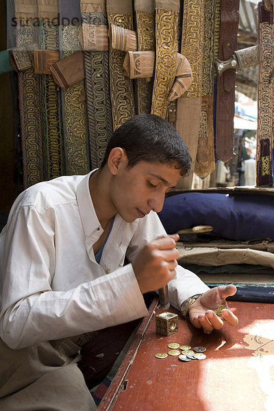 Junger Mann beim Prägen von Münzen zur Verzierung von Krummdolchen  Suq  Sana´a  Jemen  Naher Osten