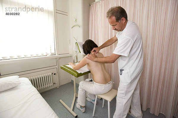 Masseur führt eine klassische Massage auf einem Massagesitz an einer Patientin durch