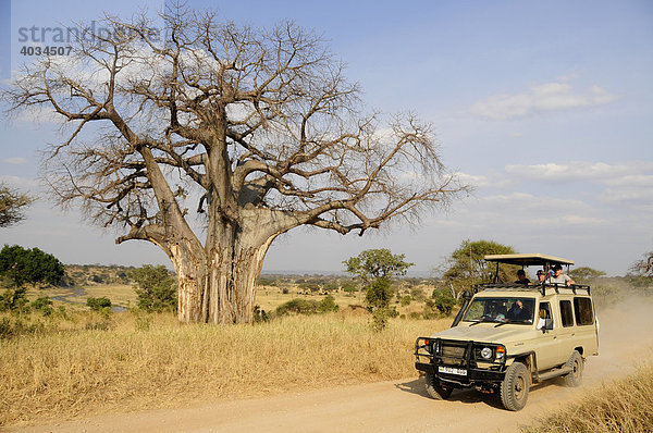 Touristen auf Safari im Geländewagen unter Baobab-Baum  Affenbrotbaum (Adansonia digitata)  Tarangire-Nationalpark  Tansania  Afrika