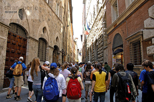 Gruppe Jugendlicher mit Tagesrucksäcken in einer Gassen von Lucca  Toskana  Italien  Europa