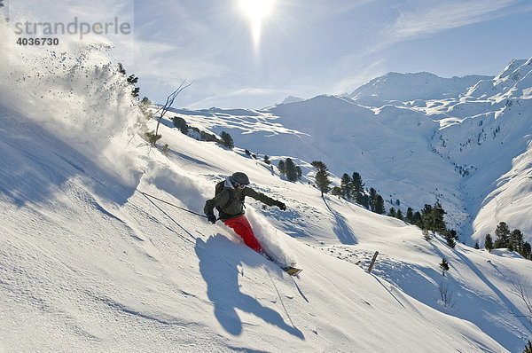 Tiefschnee Skifahrer  Freerider  im Tiefschnee mit Alpenpanorama und Sonne
