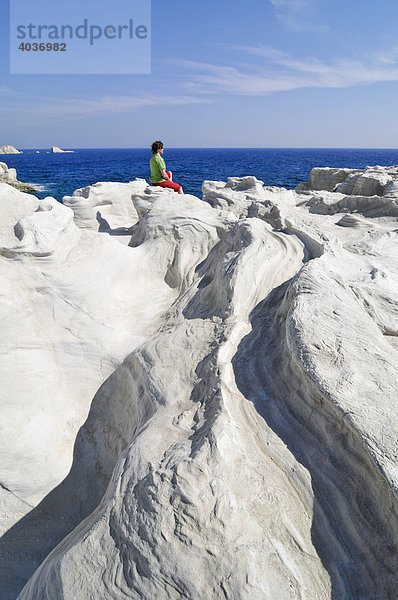 Frau sitzt auf weißen Felsformationen von Sarakiniko auf Milos  Kykladen  Griechenland  Europa