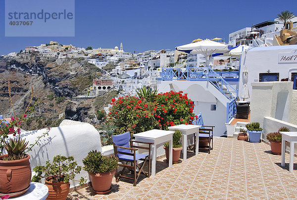 Terrasse eines kleinen Hotels mit Blumenschmuck  hinten die Stadt Fira  Thira  Santorin  Santorini  Kykladen  Griechenland  Europa