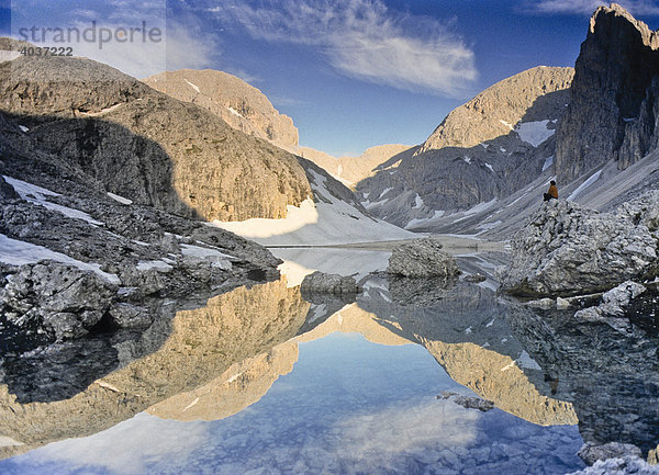 Wanderer sitzt am Bergsee Lago di Antermoia  Rosengarten  Südtirol  Italien  Europa