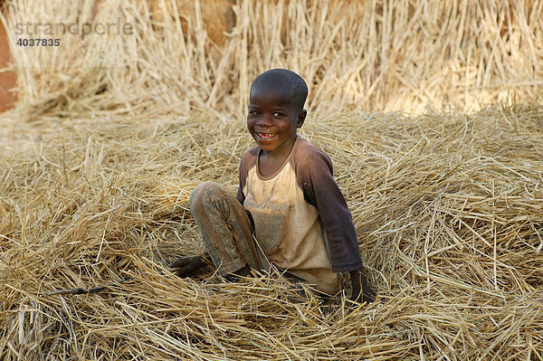 Junge spielt im Stroh  Houssere Faourou  Kamerun  Afrika