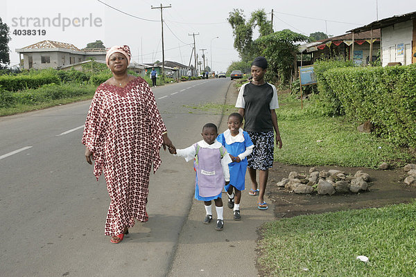 Vorschulkinder mit ihren Müttern auf dem Weg zum morgendlichen Exerzieren  Buea  Kamerun  Afrika