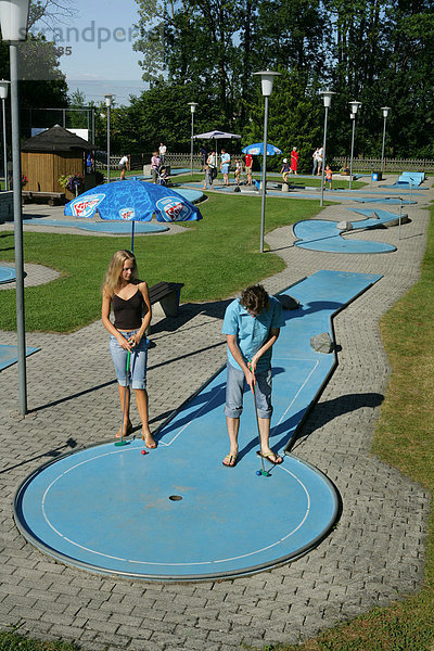 Junges Paar beim Minigolf spielen  Landkreis Mühldorf  Oberbayern  Deutschland  Europa