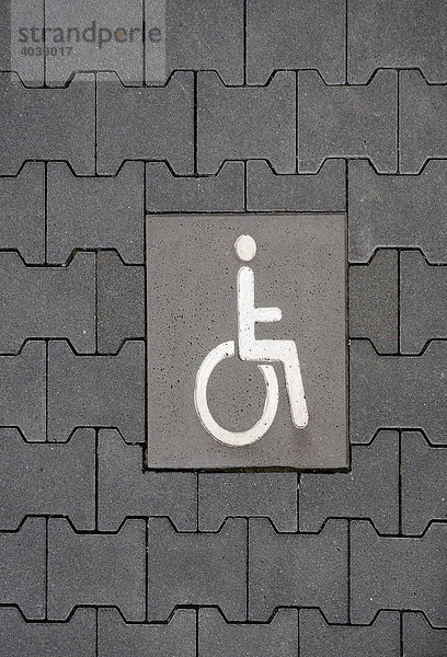 Behindertenparkplatz mit Rollstuhlfahrerpiktogramm im Pflaster