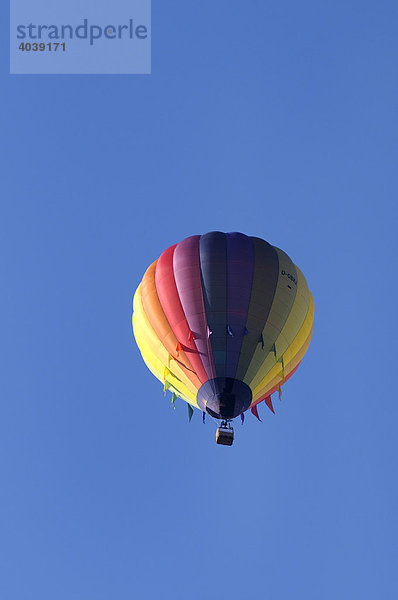 Regenbogenfarbener Fesselballon am blauen Himmel  Heißluftballon