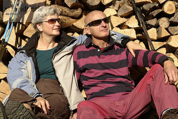 Senioren Paar entspannt vor Holzstoß
