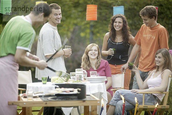 Gruppe junger Leute beim Barbecue im Garten