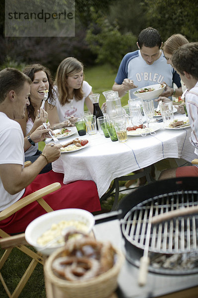 Gruppe junger Leute beim Barbecue im Garten