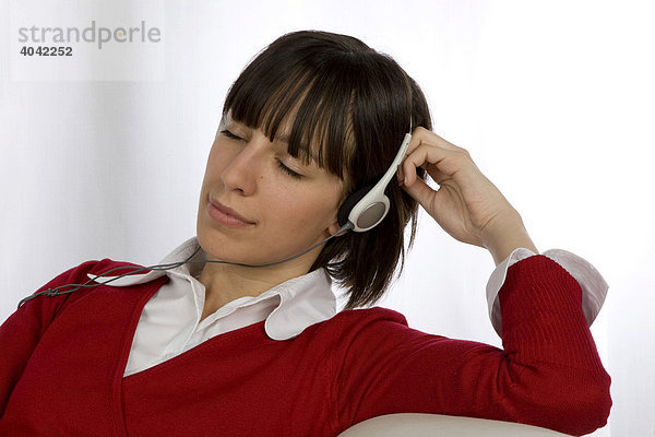 Frau  20-jährig  hört entspannt Musik mit Kopfhörer
