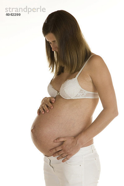 Schwangere Frau hält liebevoll ihren Bauch