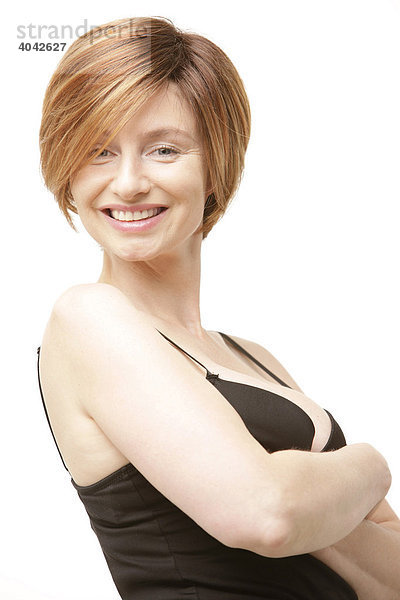 Frau mit Victoria-Beckham-Frisur und schwarzem Top  Arme verschränkt  lacht