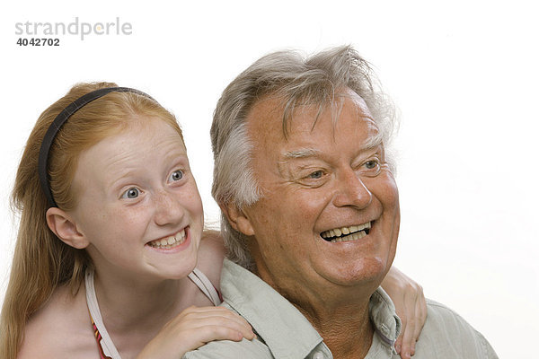 8-jähriges Mädchen mit roten Haaren umarmt ihren Großvater  lachen