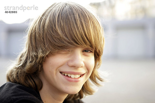 12-jähriger Junge mit blonden Haaren  lacht