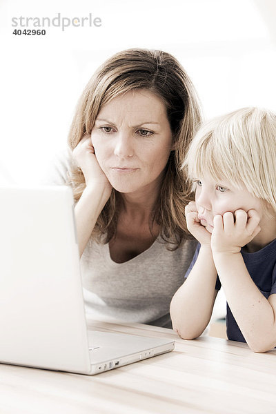 Mutter mit Sohn am Laptop  ratlos