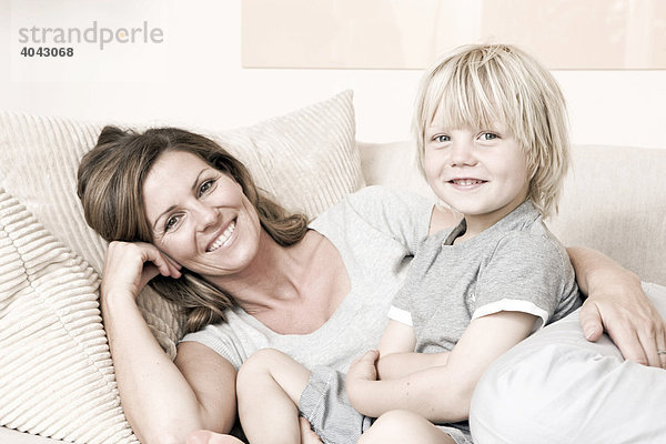 Mutter und Sohn auf dem Sofa  lächeln