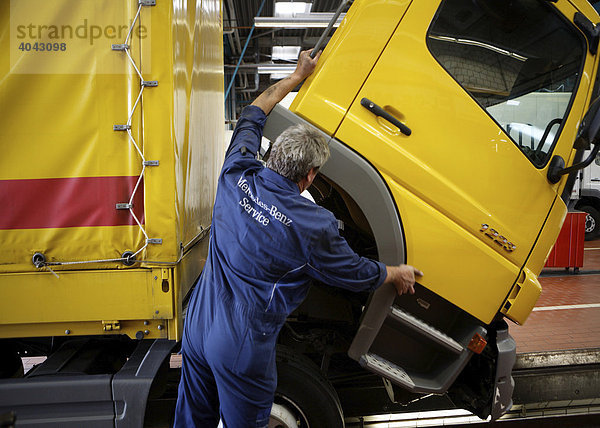 Kfz-Mechaniker kippt die Fahrerkabine eines LKW nach vorne in der Nutzfahrzeug-Werkstatt in der Daimler AG  Mercedes Benz Niederlassung Stuttgart  Service Center Böblingen  Baden-Württemberg  Deutschland  Europa