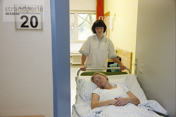 Krankenschwestern schieben eine Patientin über den Stationsflur eines Krankenhauses