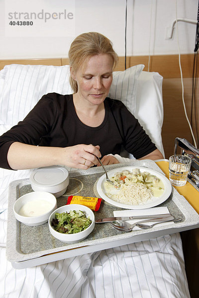 Patientin beim Essen im Bett im Krankenhaus