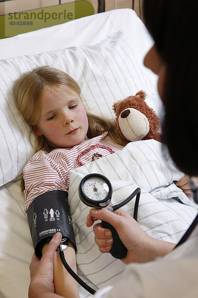 Krankenschwester misst den Blutdruck einer jungen Patientin  7 Jahre  im Krankenhaus