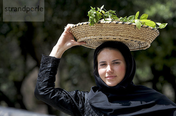 Junge Frau mit Korb auf dem Kopf in traditionellem Kostüm auf der Cavalcata Sarda in Sassari  Sardinien  Italien  Europa
