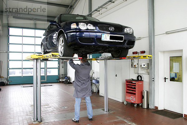 Mann prüft Auto in einer Werkstatt