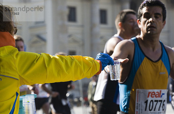 Helferin reicht einem Läufer einen Becher mit Wasser beim Berlin Marathon 2008  Berlin  Deutschland  Europa