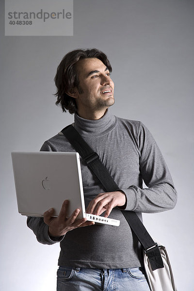 Junger Mann mit Laptop und Tasche