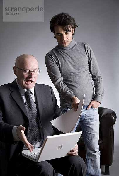 Geschäftsmann mit Assistent am Laptop