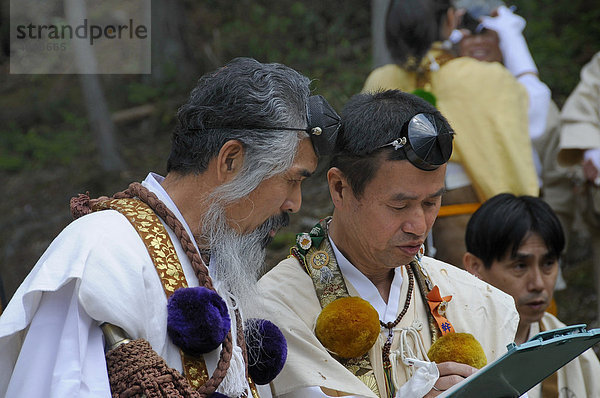Yamabushi unterschiedlicher Rangstufen mit typischer Kopfbedeckung und Kleidung besprechen den Ablauf der Veranstaltung  Shogoin-Tempel bei Kyoto  Japan  Asien