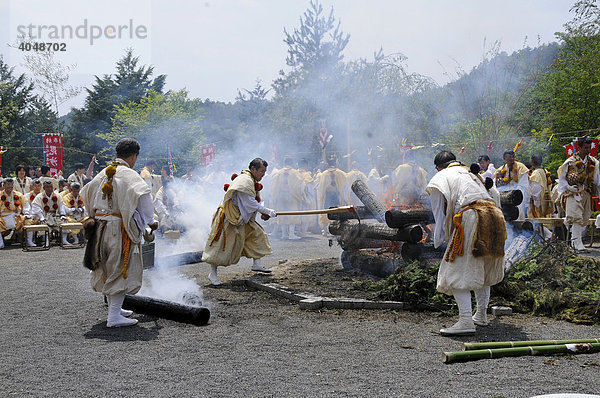 Der glühende Holzstoß wird mit Feuerhaken von Yamabushi auseinander gerissen und die glühenden Stämme weggeschleppt  Kyoto  Japan  Asien