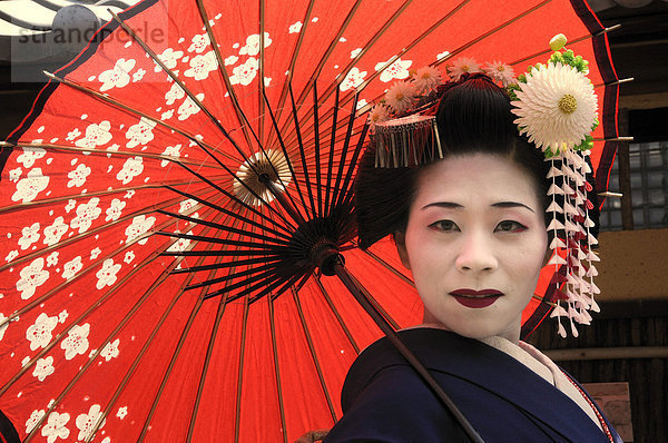 Maiko  Geisha in Ausbildung  mit rotem Sonnenschirm  Kyoto  Japan  Asien