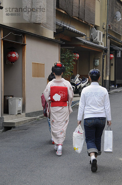 Maiko  Geisha in Ausbildung  mit Assistentin auf dem Weg zum Odori im Gion Viertel  Kyoto  Japan  Asien