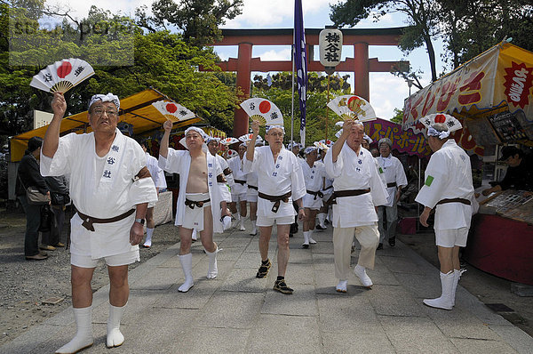 Die Tragegriffe der Schreine werden unter Wedeln der Fächer herangetragen  Schreinfest Matsuri des Matsuo Taisha Schreins  Shintoismus  Kyoto  Japan  Asien