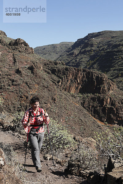 Frau wandert mit Wanderstöcken  Barranco de Argaga  La Gomera  Kanarische Inseln  Kanaren  Spanien  Europa