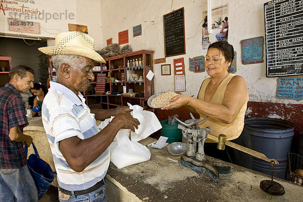 Kubaner bekommt von Verkäuferin auf Essenskarten Lebensmittel in einem Geschäft zugeteilt  Trinidad  Provinz Sancti-Spíritus  Kuba  Cuba  Lateinamerika  Amerika
