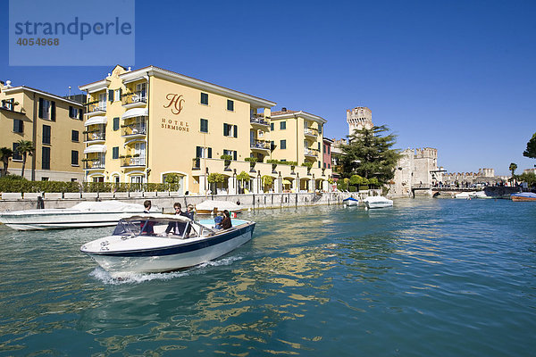 Ein Motorboot mit Touristen verlässt den Hafen  Ortschaft Sirmione  Gardasee  Lago di Garda  Lombardei  Italien  Europa